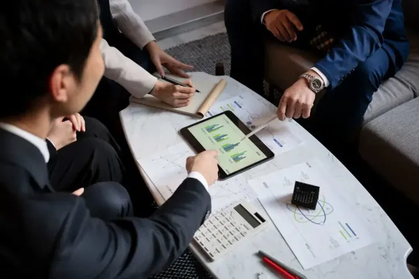 Team reviewing charts and data on a tablet and printed reports.